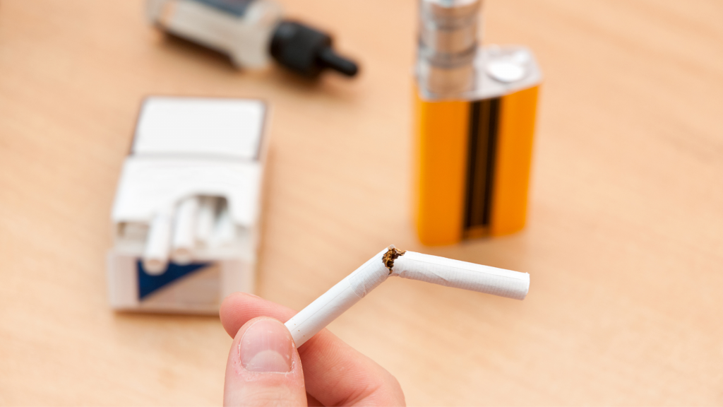 Broken cigarette with harm reduction products behind