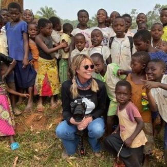 Image of a woman surrounded by kids.