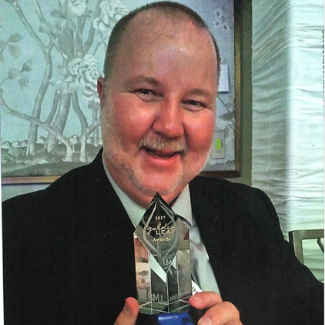 Portrait of a man holding an award.