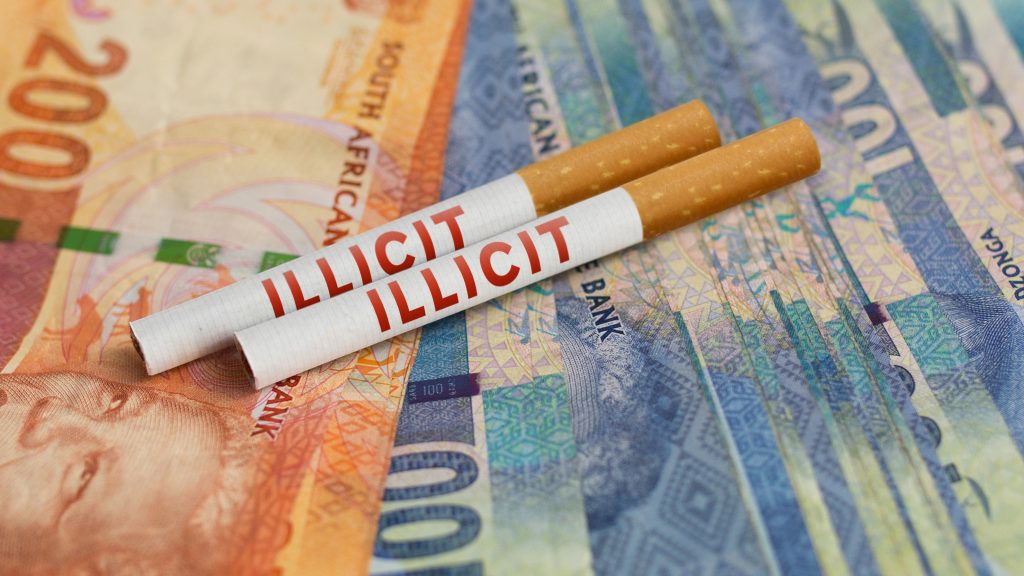 Two cigarettes with text reading "illicit" on top of South African currency.
