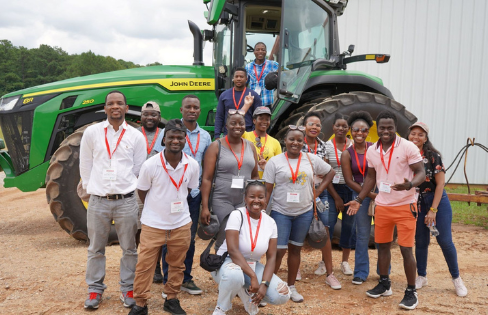 Malawian Scholars gather in front of tractor