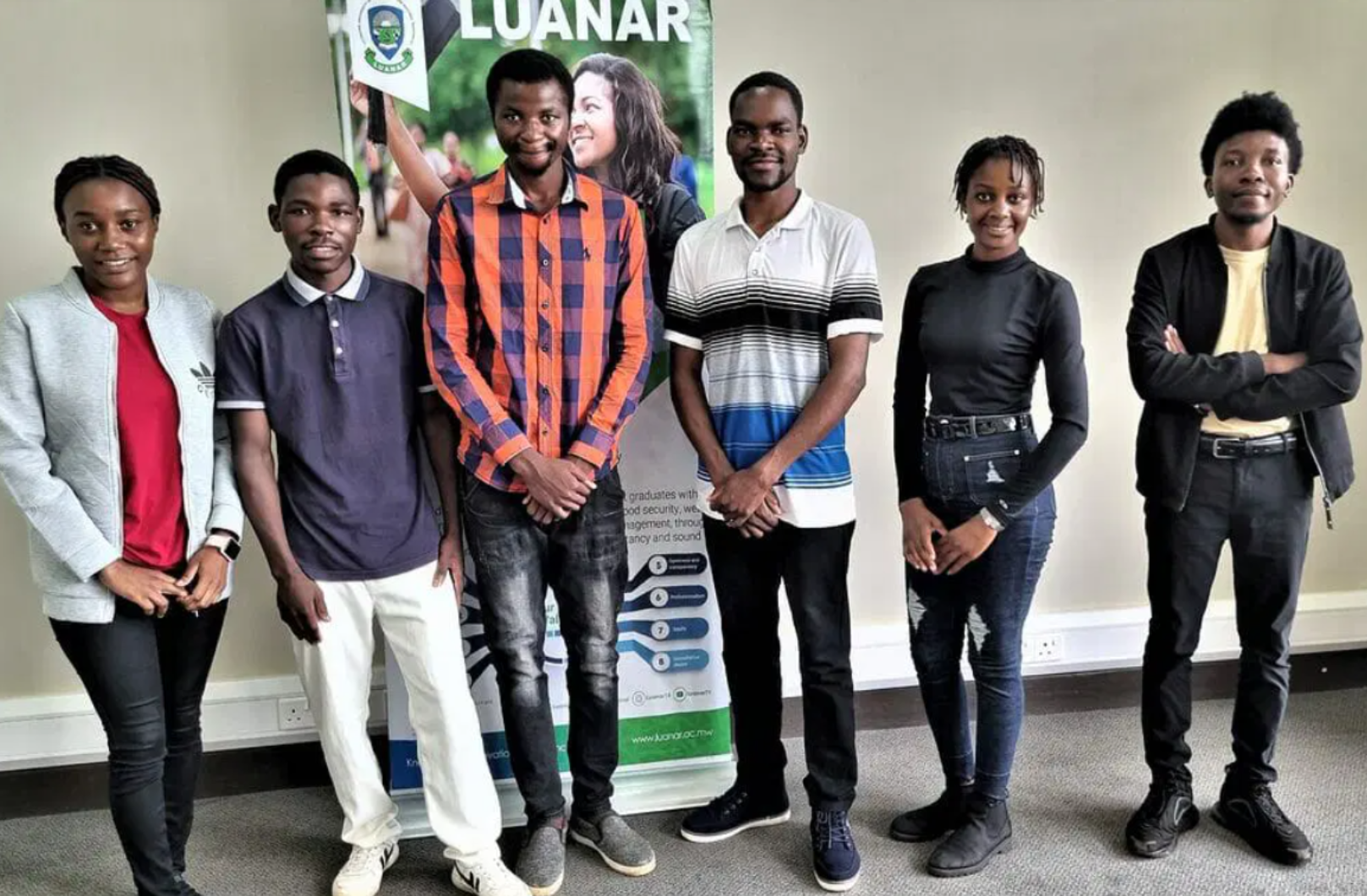 6 students standing in front of a LUANAR sign